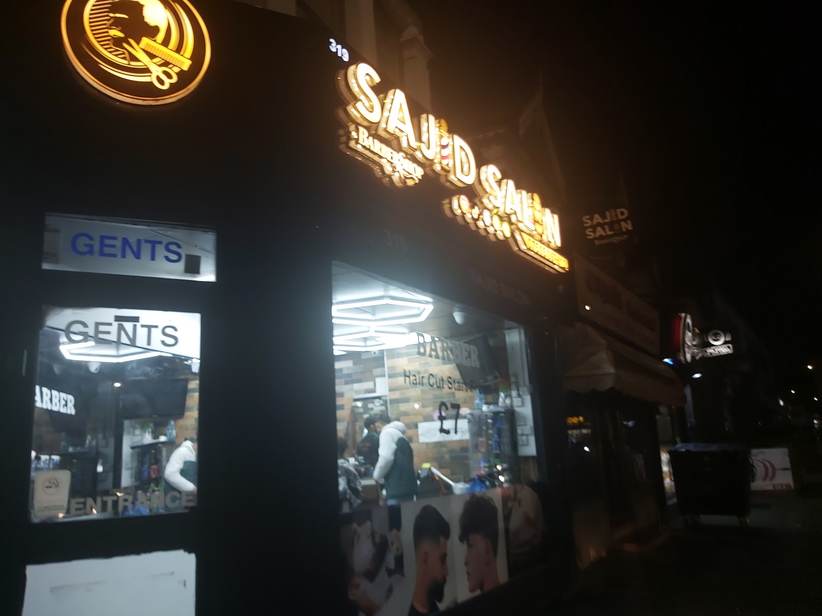 The salon frontage seen along the street after dark